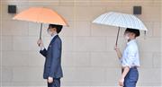 雨晴兼用傘を差せば、ソーシャルディスタンスを保ちやすい。オレンジ色や淡いストライプ柄を取り入れて、明るい印象に（いずれもオーロラ、１万３２００円）＝宮崎瑞穂撮影