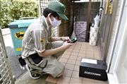 依頼を受けて「置き配」をするヤマト運輸の配達員＝３日、東京都内