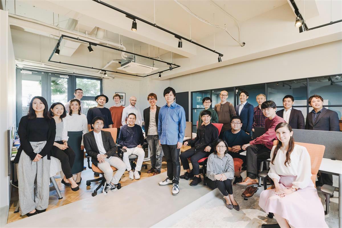 九大発医療ＩＴベンチャーのメドメインの従業員に囲まれる飯塚統最高経営責任者（ＣＥＯ、写真中央、同社提供）