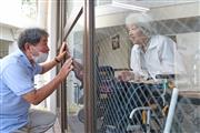 森沢祐治さん（左）が窓越しに話しかけると、妻の康子さんはうれしそうにうなずいた＝大阪府四條畷市（彦野公太朗撮影）