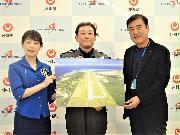 下地島空港の写真を手にするＰＤエアロスペースの緒川修治社長（中央）＝１１日、東京都港区（松村信仁撮影）