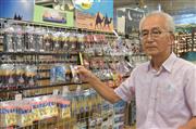 店内でオリジナルストラップを手にする内山浩さん（平田浩一撮影）