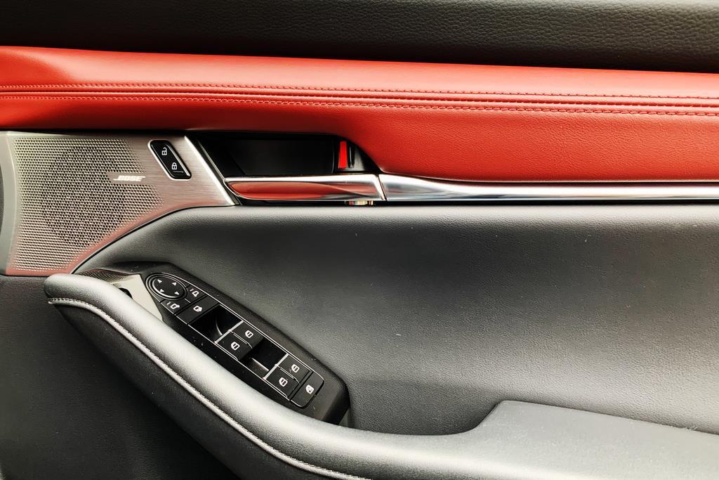 ドアトリムにあしらったレッドの合成皮革やメタルパーツ。スピーカーはBOSE製。ハンドグリップの造形もオシャレだ