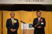 菅義偉首相（左）から贈られた日本サービス大賞・内閣総理大臣賞の盾を持つコマツの大橋徹二会長＝２７日、東京都港区（平尾孝撮影）