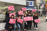 渋谷のスクランブル交差点で「How can I help you ？」の看板を持つ街頭ボランティア（Japan Local Buddy提供）