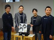 小型衛星の模型とともに撮影に応じるアクセルスペースの中村友哉社長（右から２人目）＝２６日、東京都中央区（松村信仁撮影）