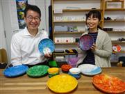 プラスチックごみを材料にした皿などを手にするテクノラボの林光邦社長（左）と田所沙弓さん　＝横浜市神奈川区