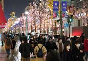 クリスマスイブを迎え、イルミネーションで彩られた御堂筋をマスク姿で行きかう人々＝１２月２４日午後、大阪市中央区（恵守乾撮影）