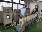 モリモト医薬が開発した液剤を連続凍結乾燥する新たな技術を使った装置。白い円盤で区切られた区画ごとに温度を制御して高品質の粉末製剤を生産する（モリモト医薬提供）