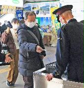 秩父鉄道熊谷駅の改札口で、紙の切符を確認する駅員（右）＝１６日午前、埼玉県熊谷市（竹之内秀介撮影）