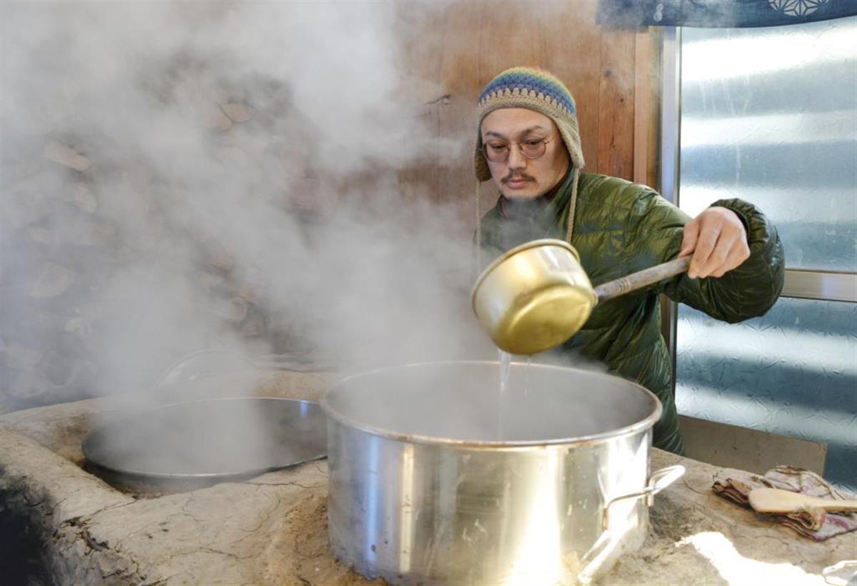 「松之山温泉」の温泉水を煮詰める嶋村彰さん＝１日、新潟県十日町市