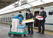 鹿児島中央駅から新幹線で到着した鮮魚や野菜などの荷物を運び出す関係者ら＝２６日午後、ＪＲ新大阪駅（恵守乾撮影）