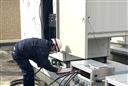 専用装置（右）を使った自家発電機の点検の様子。建物内の停電は不要という（消防管理協会提供）