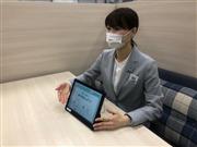 タブレット型営業端末を使い説明する営業担当者