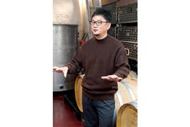 島之内フジマル醸造所の貯蔵庫に並ぶワイン樽とオーナーの藤丸智史さん＝大阪市中央区（前川純一郎撮影）