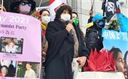中国政府の人権侵害に抗議の声をあげるエズズさん（中央）＝3月7日、東京都渋谷区の国連大学前