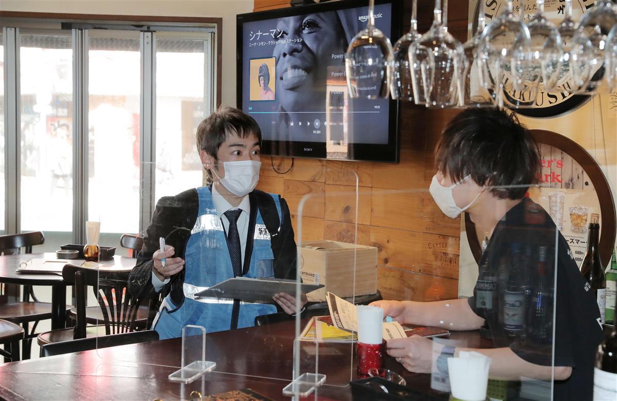 新潟駅周辺の飲食店を訪問し店長に新型コロナ対策の徹底を呼び掛ける新潟市職員（左）＝９日、同市中央区（代表撮影）