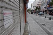 沖縄観光のメーンストリート「国際通り」。人通りは少なく、シャッターを閉めた店が目立った＝２１日午前、那覇市（川瀬弘至撮影）