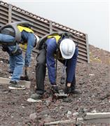 ＡＴＯＵＮ（アトウン）の腰装着型アシストスーツを着けた山梨県職員が富士登山道の復旧作業にあたった　（同社提供）