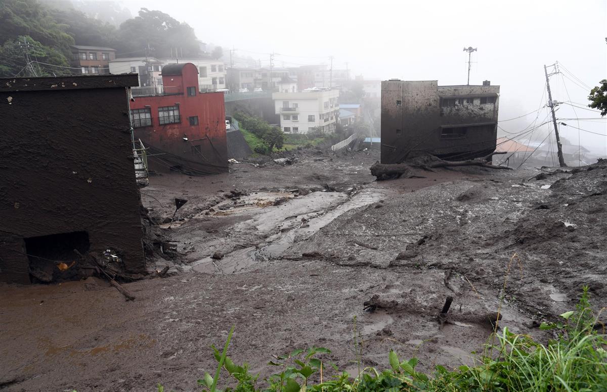 熱海市伊豆山で起こった土砂崩れ現場。左端の建物の屋根付近まで土砂がついている＝３日午後、静岡県熱海市（鴨川一也撮影）