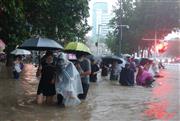 大雨で冠水した中国河南省鄭州市内を歩く市民＝２０日（共同）