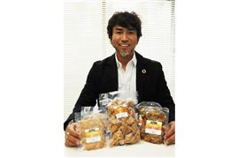 早大レスリング部に送った「ソイミート」シリーズを片手に「若いアスリートを積極的に支援したい」と話す小野篤人社長＝取手市東
