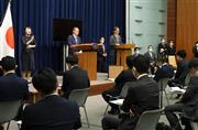 発令中の緊急事態宣言などの期間延長と区域変更が決定し会見で国民へさらなる協力を求める菅義偉首相。右奥は政府分科会・尾身茂会長＝３０日午後、首相官邸（春名中撮影）