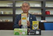 １箱５０枚入りの商品を手にする武内英治社長