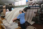 起毛機にかけられた織毛布。何回かけて、どんな風合いに仕上げるかは熟練工の判断だ＝大阪府泉大津市の今新毛織