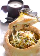 ナンの蓋をナイフで切り開くと、ふっくらと炊けたビリヤニが現れた＝東京・南青山の「シターラ」（酒巻俊介撮影）