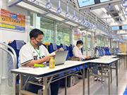 仕事が終われば、すぐに野球観戦へ－。西武球場前駅に停車した電車の中でテレワークをする人たち＝７日午後、埼玉県所沢市（中村智隆撮影）