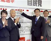 衆院選挙の当選確実が出た候補者の名前にバラの花をつける岸田文雄首相（中央）と自民党幹部ら＝１０月３１日午後、東京・永田町の自民党本部（春名中撮影）