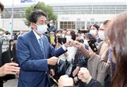 聴衆とグータッチを交わす安倍晋三元首相＝１０月２１日午後、横浜市のＪＲ桜木町駅前（矢島康弘撮影）