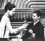 １９８６年３月、米アカデミー賞衣装デザイン賞を受賞したワダエミさん（右）。オードリー・ヘプバーンさんからオスカー像を手渡された（ＵＰＩ＝共同）