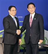 ２日、ベトナムのファム・ミン・チン首相（左）と握手する岸田首相＝英グラスゴー（代表撮影・共同）