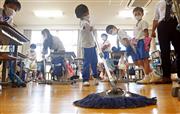 ほこりが舞い上がらないようにモップで掃除する児童ら＝２日午後、奈良市の奈良学園小学校（須谷友郁撮影）